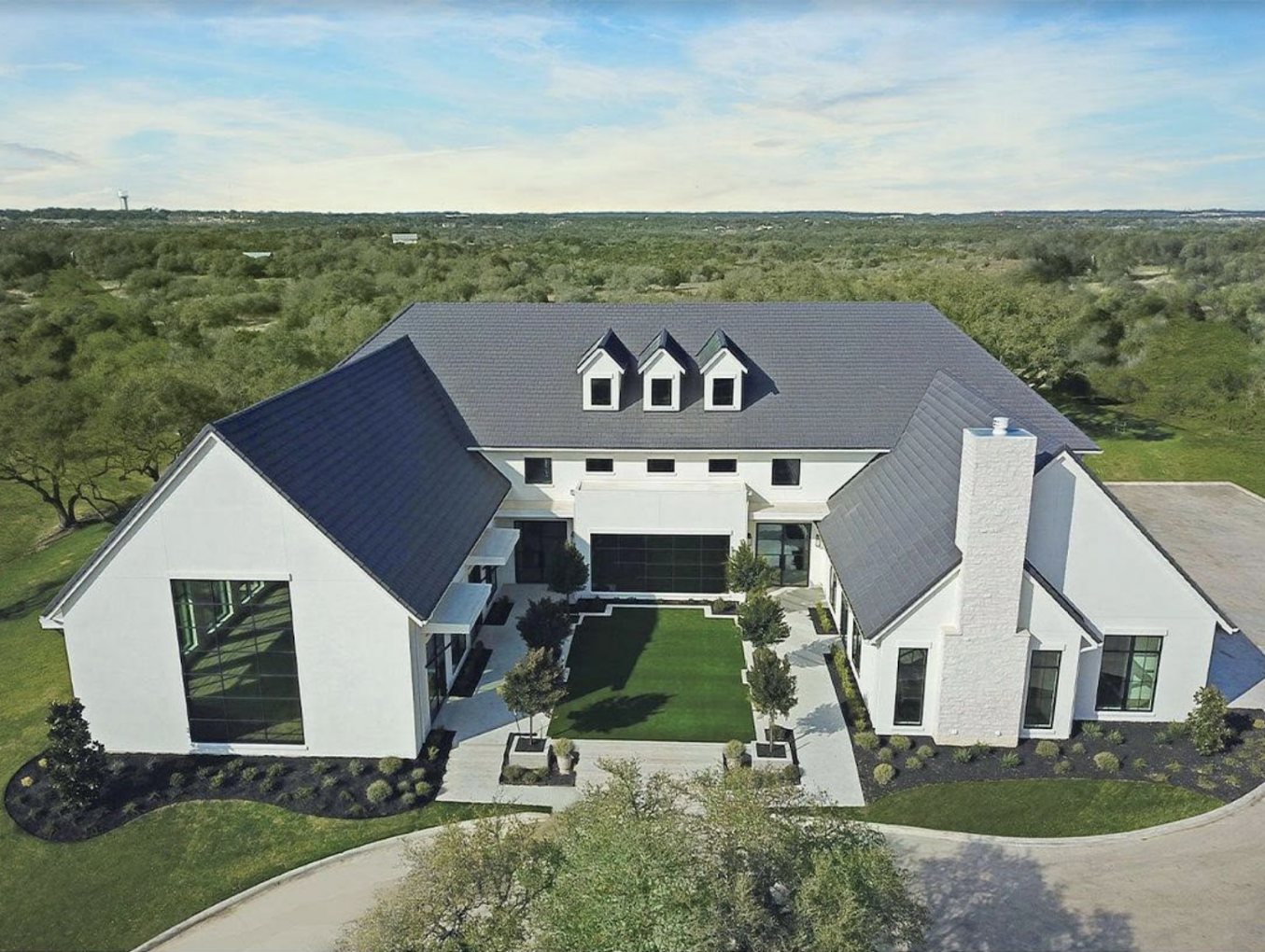 Aerial view of the Arlo wedding venue's modern white farmhouse in the Texas Hill Country