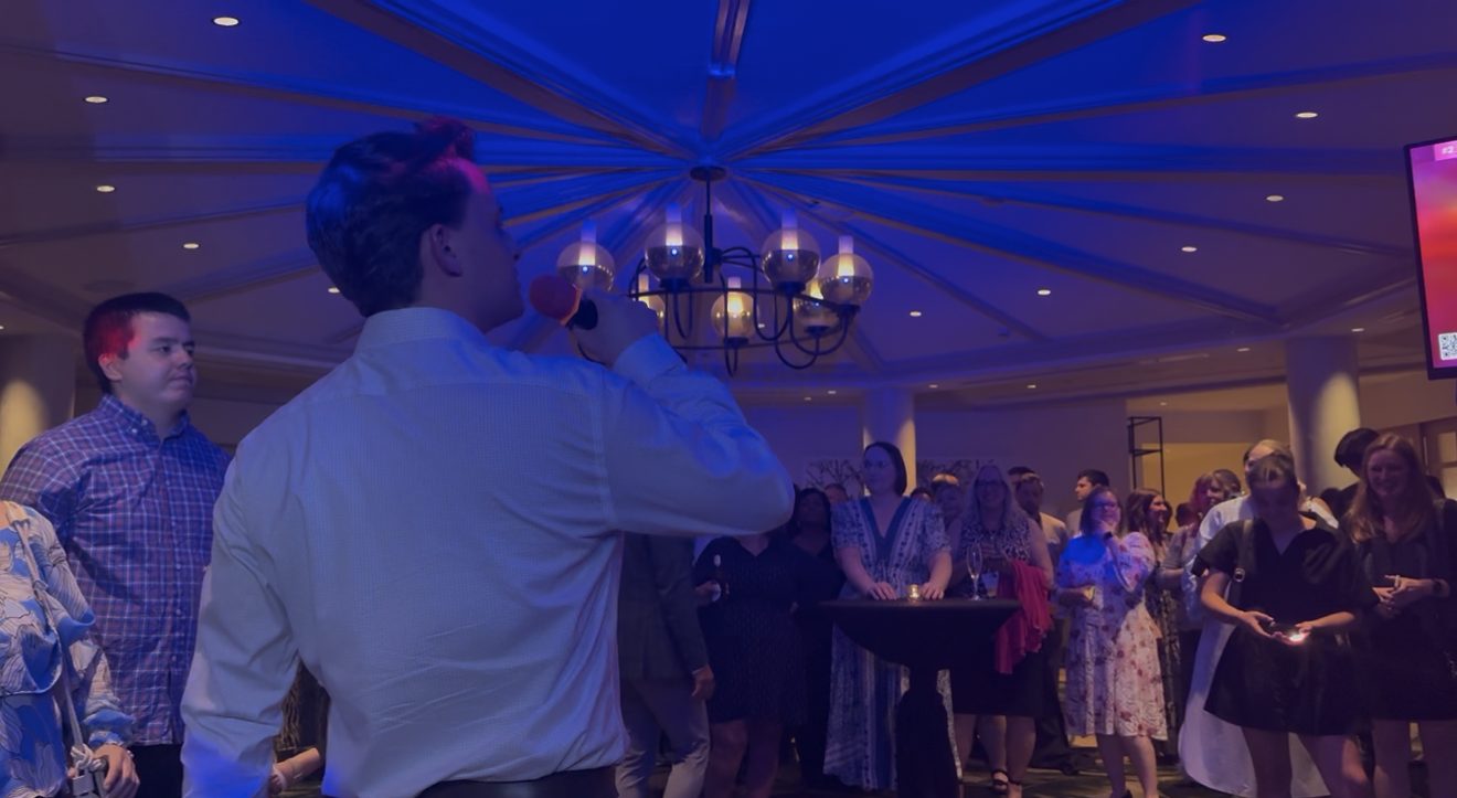 Guest singing karaoke under blue event lighting at a Central Texas party