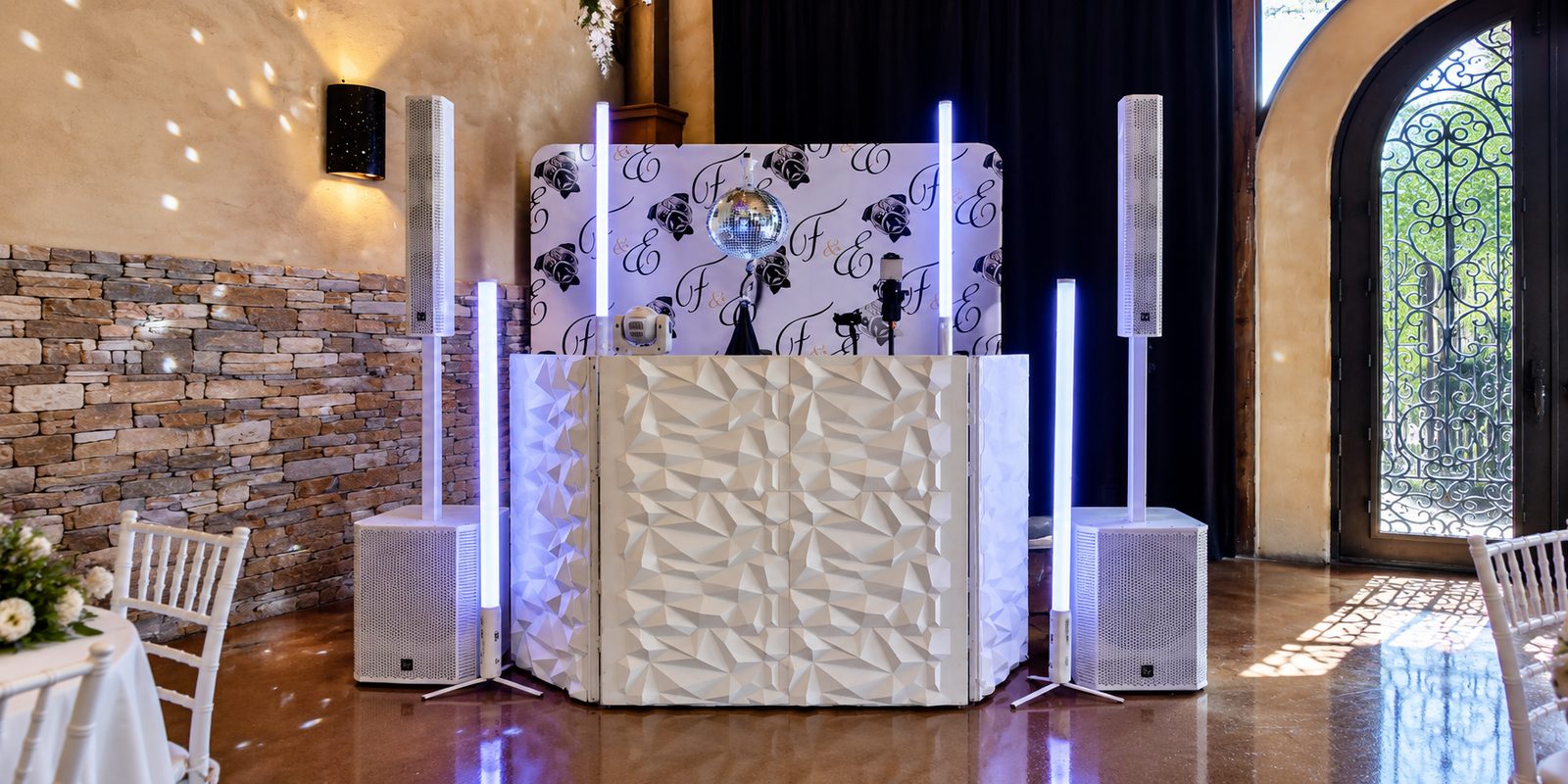 Silver Lining DJ setup with disco ball, LED tube lighting and a custom monogram backdrop at Tuscan Hall in Austin, TX