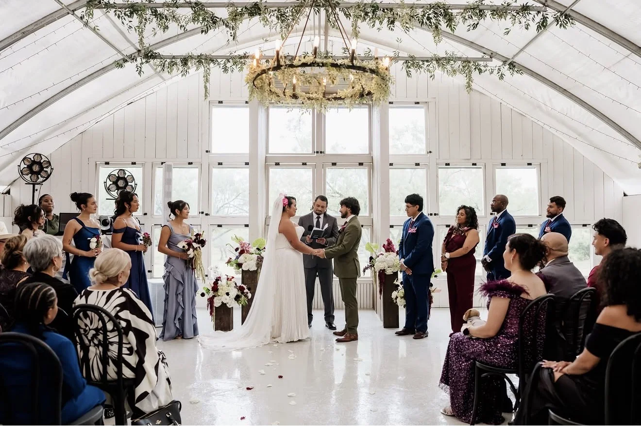 Bride and groom at the altar in a white barn wedding venue in the Texas Hill Country